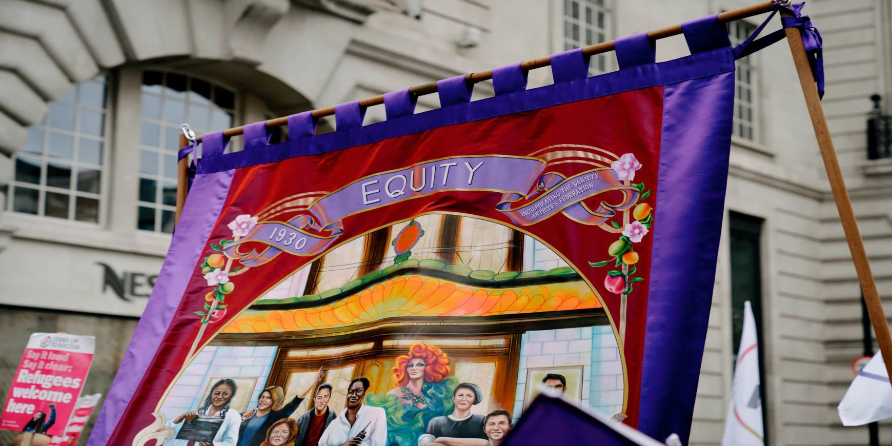 Painted purple and red Equity Banner with the date 1930, showing a variety of different performers.