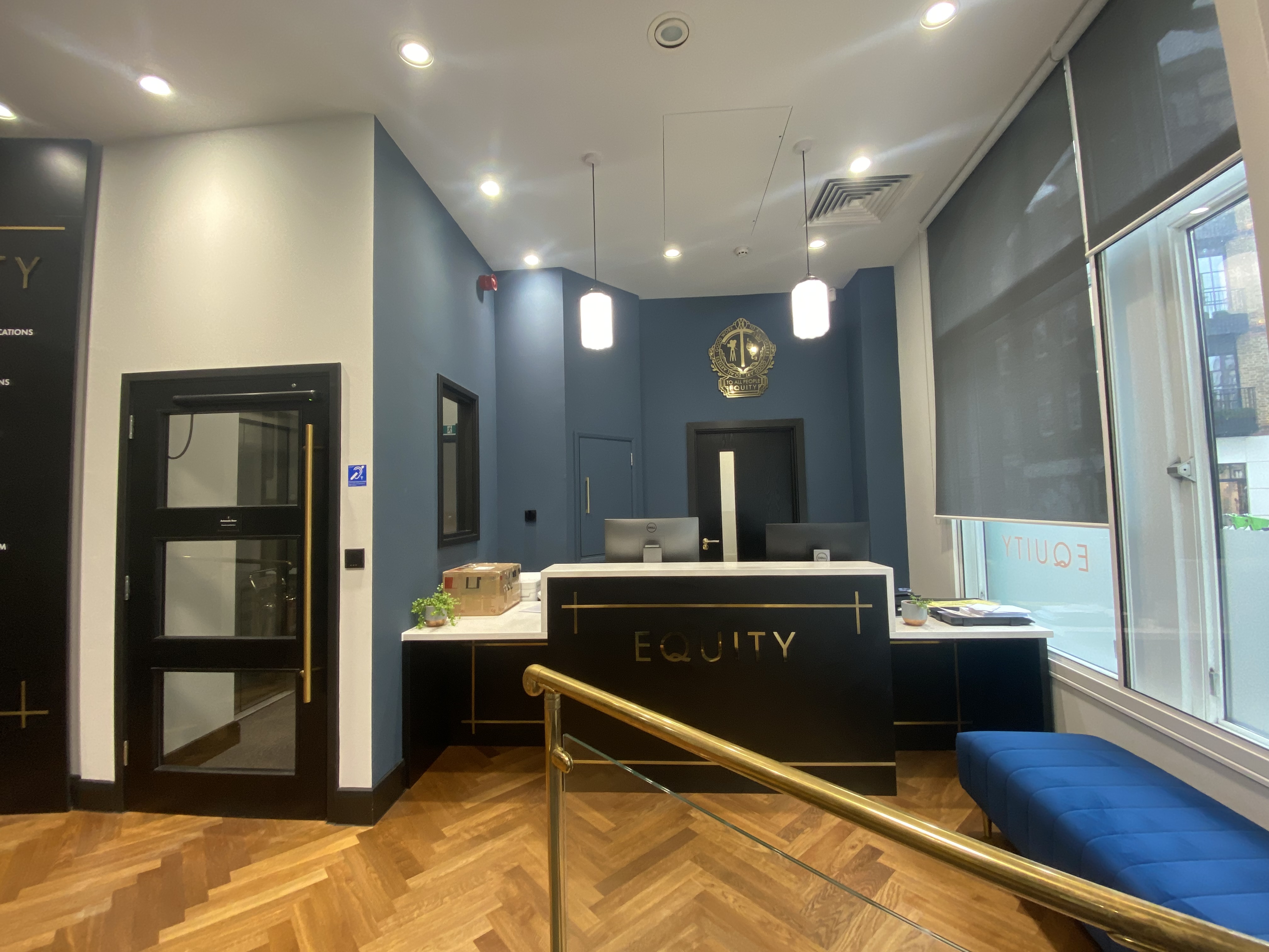 Photo shows Equity reception desk on the right hand side with an internal door to the left of the desk and windows to the right of the desk.